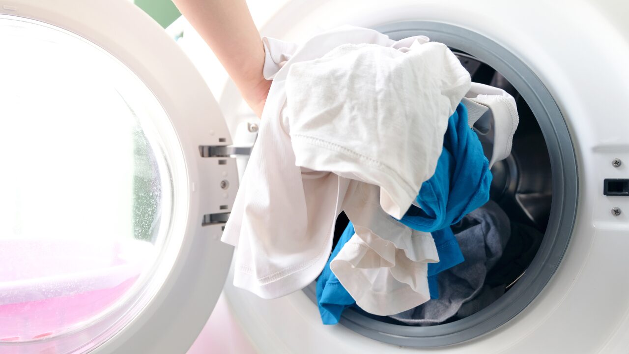 ドラム式洗濯機に洗濯物を入れている